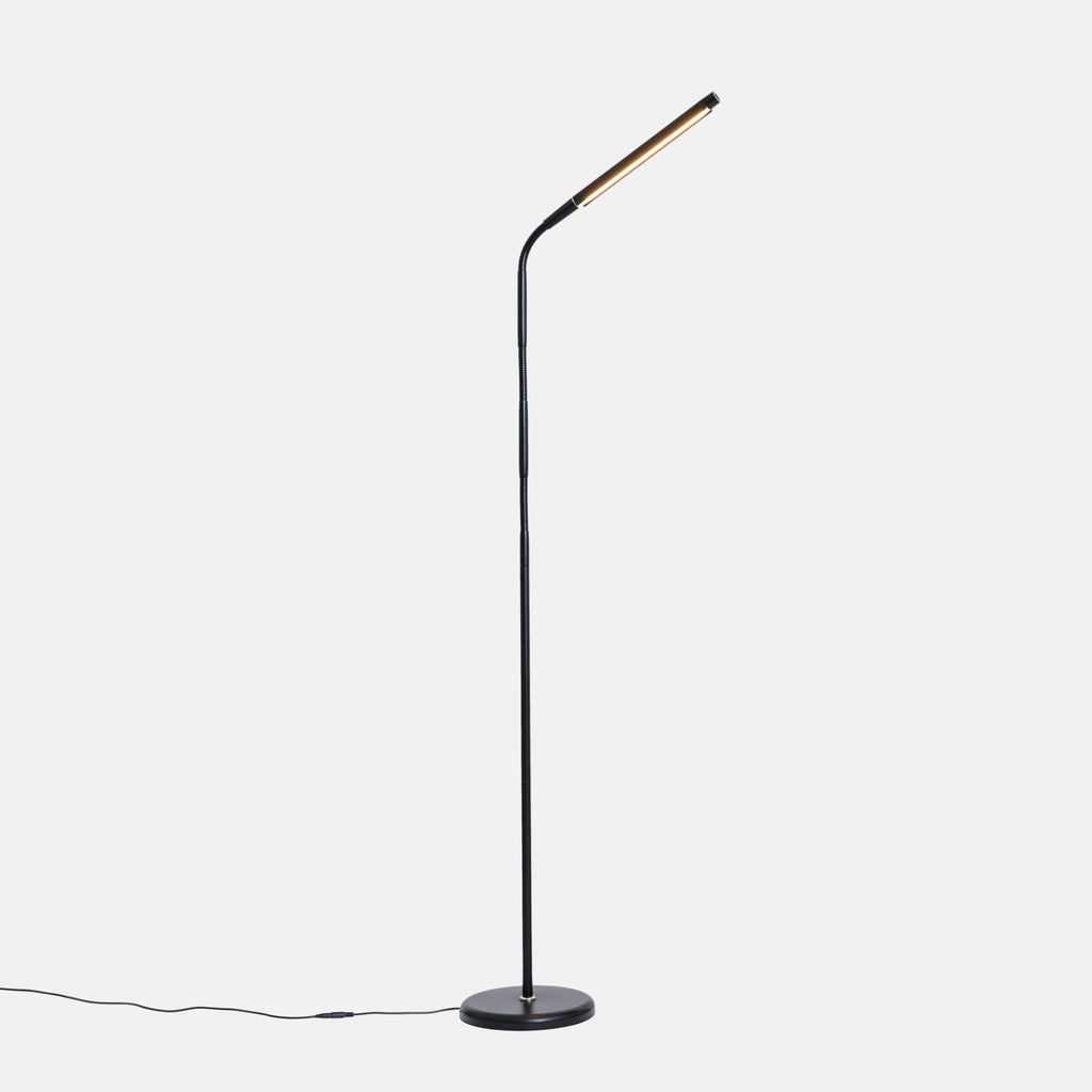 Modern floor lamp with a curved design on a white background. Light is on an angled arm.