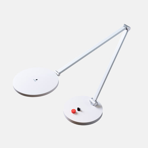 A modern white adjustable desk lamp with two circular lamp heads and a slim articulated arm, shown on a light gray background.