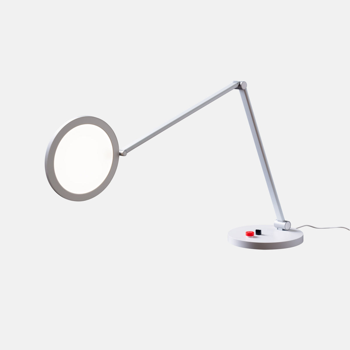Modern desk lamp with adjustable arm and magnifier circular head on a white background