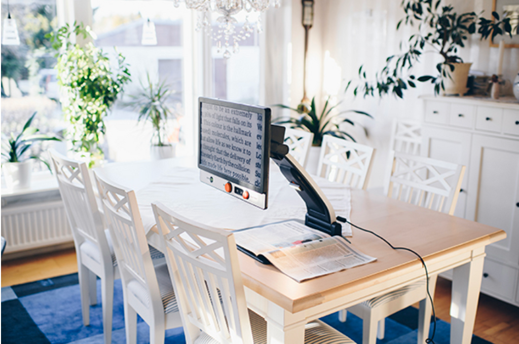 Dining room with a table and chairs, with Magnilink One 17" and plants around.