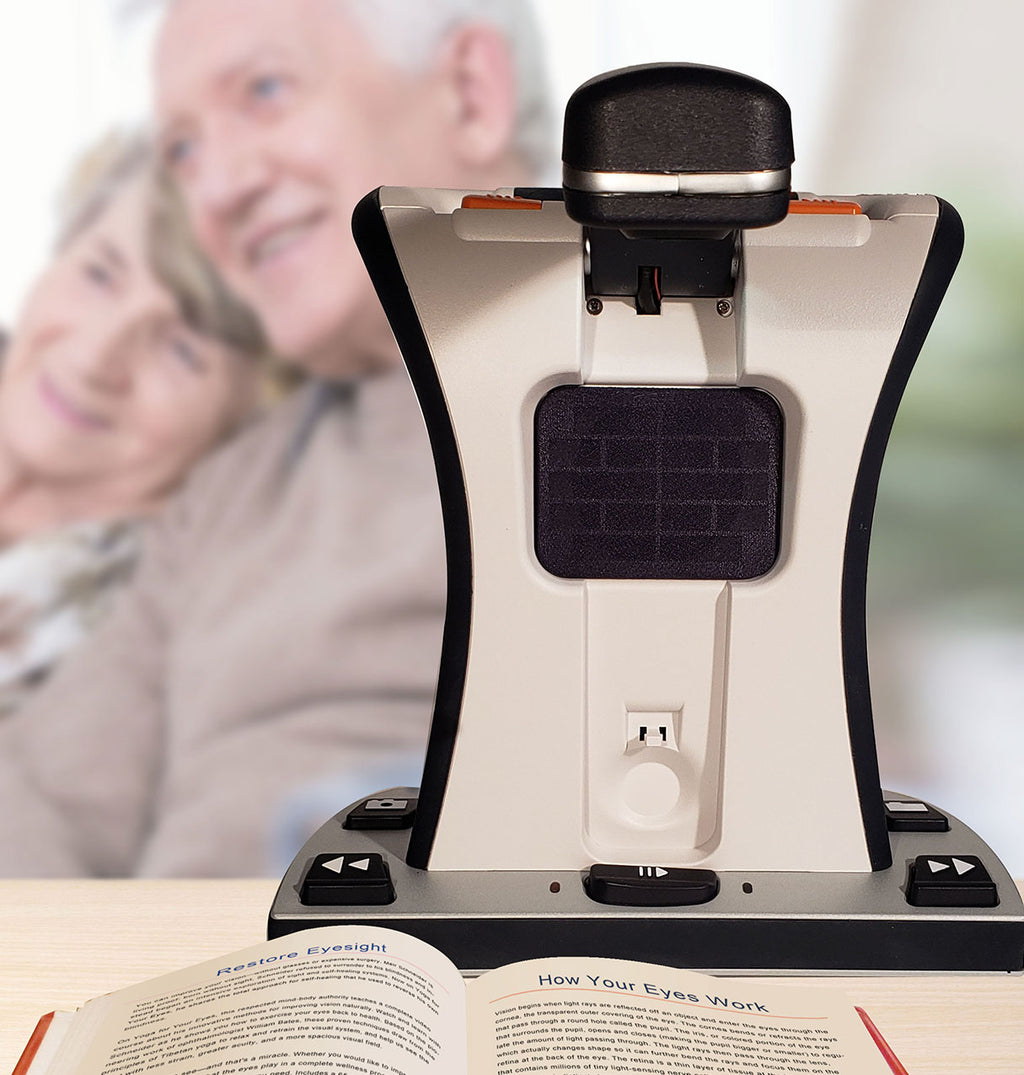 Smart Reader HD on a desk with a blurred background of two people smiling
